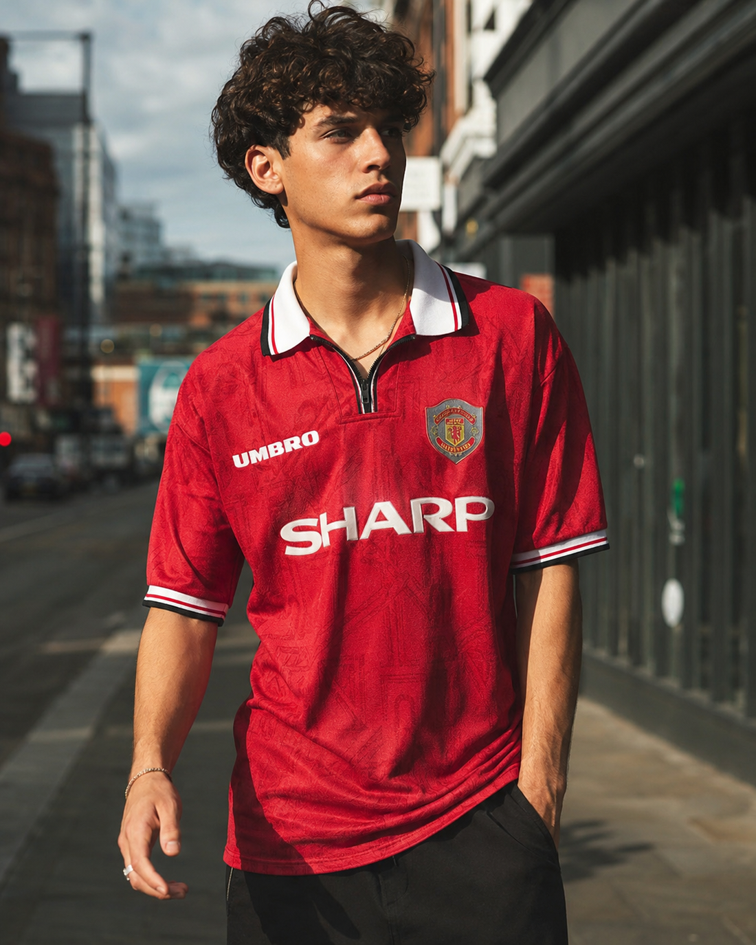 Model wearing a 1990s Manchester United home shirt with the Sharp sponsor